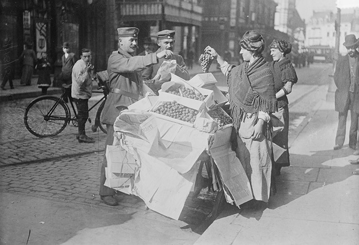 Des soldats allemands achètent des fruits à un étalage dans la Belgique occupée