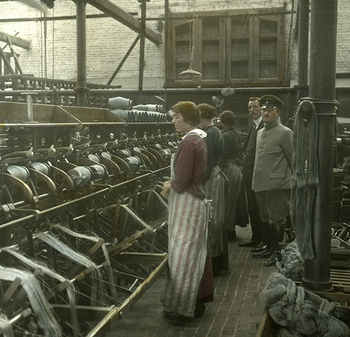 Un soldat allemand à côté d’ouvrières d’une usine textile à Menin en Belgique
